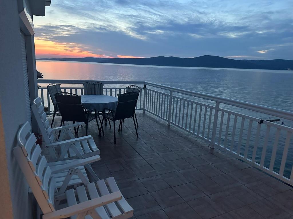 a balcony with a table and chairs and a view of the water at Panorama in Drvenik Veli
