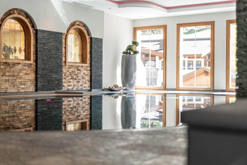 a room with a table with a vase on it at Natur & Alpinhotel Post in Vent