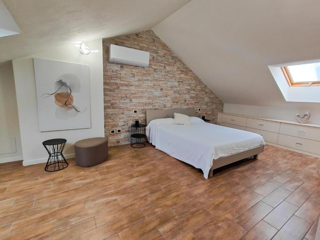a bedroom with a bed and a brick wall at Riflessi sul lago Lierna bed and breakfast in Lierna