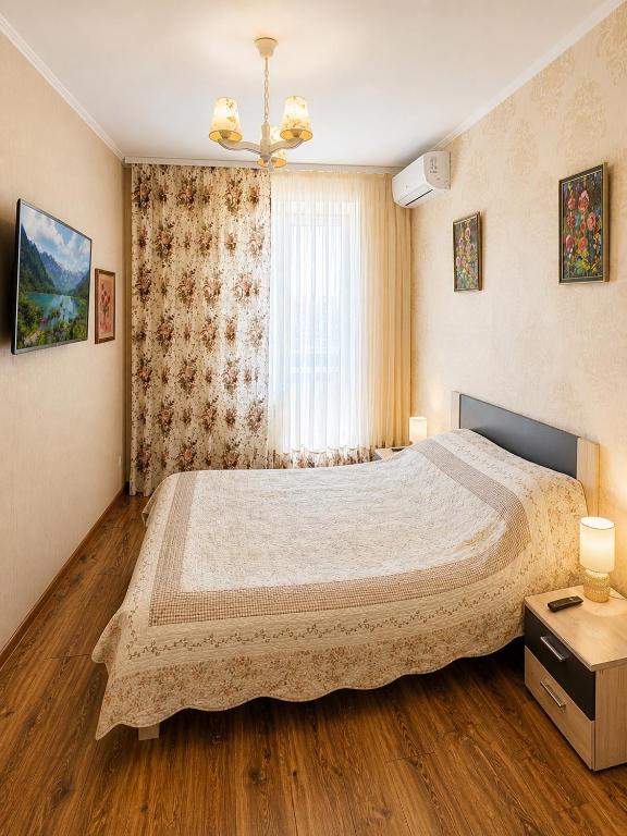 a bedroom with a large bed and a window at Sweet Home on Shevchenko street in Vinnytsya