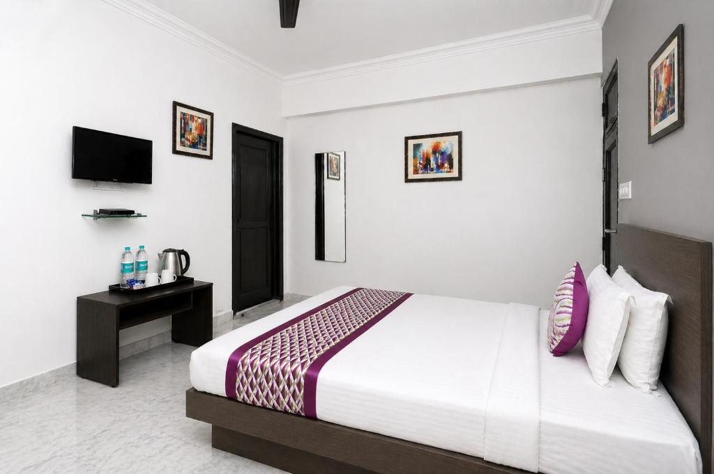 a hotel room with a bed and a television at Hotel Ace Plaza in Udaipur