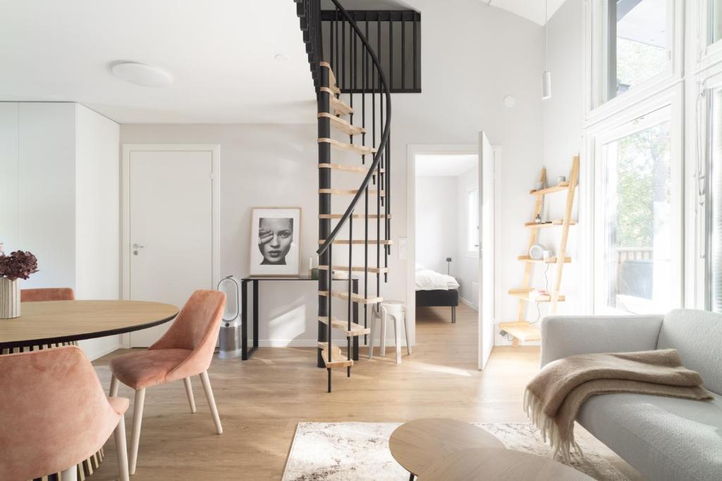 a living room with a spiral staircase and a table at Villa MiaEmilia A in Espoo