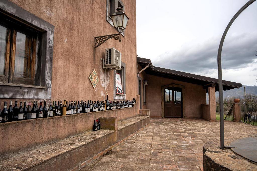 a building with a bunch of wine bottles on the wall at Tenute Sciara in Randazzo