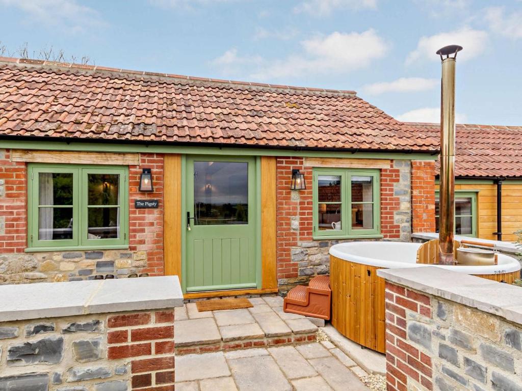 a brick house with a green door and a bath tub at 2 Bed in Taunton oc-80694 in North Curry