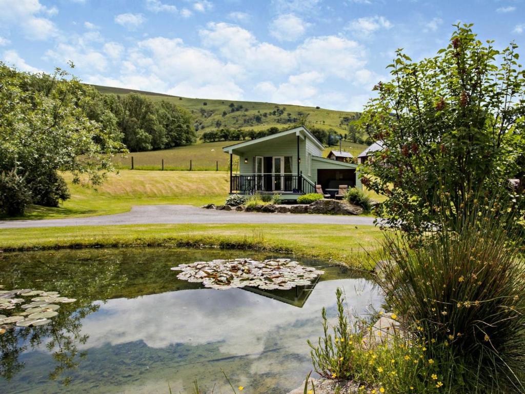 a house with a pond in front of it at 1 Bed in Llangammarch Wells oc-bn020 in Garth