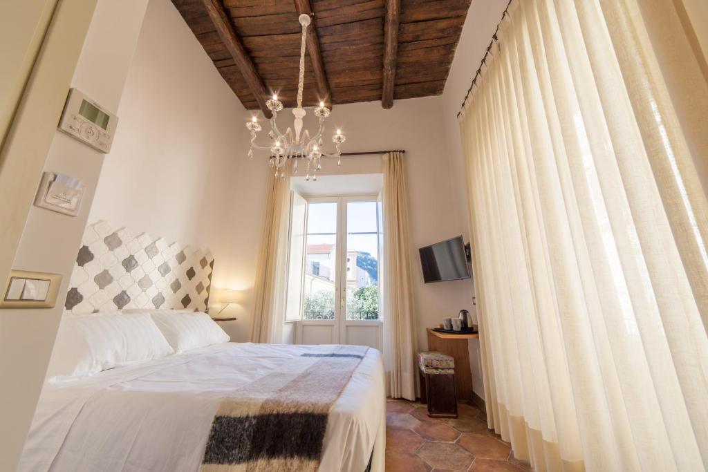 ソレントにあるResidenza Il Campanileのベッドルーム1室(ベッド1台、窓、シャンデリア付)