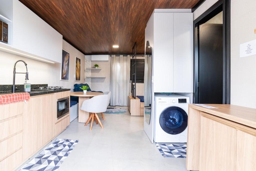 a kitchen with a washer and dryer in it at Studio Completo AC Piscina Pet Friendly NH in Novo Hamburgo