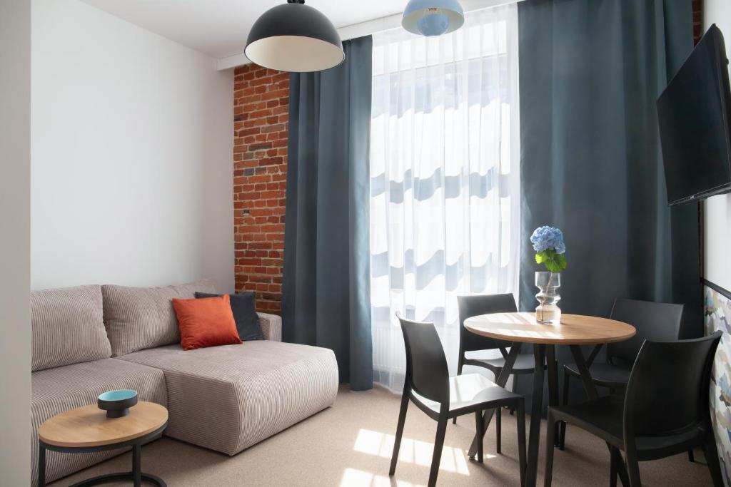 a living room with a couch and a table with chairs at New Adler Bed & Breakfast in Łódź