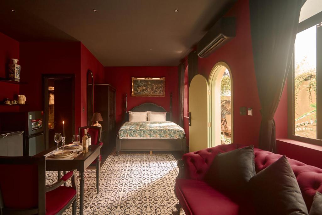 a red living room with a bed and a couch at G'Villa Thảo Điền in Ho Chi Minh City
