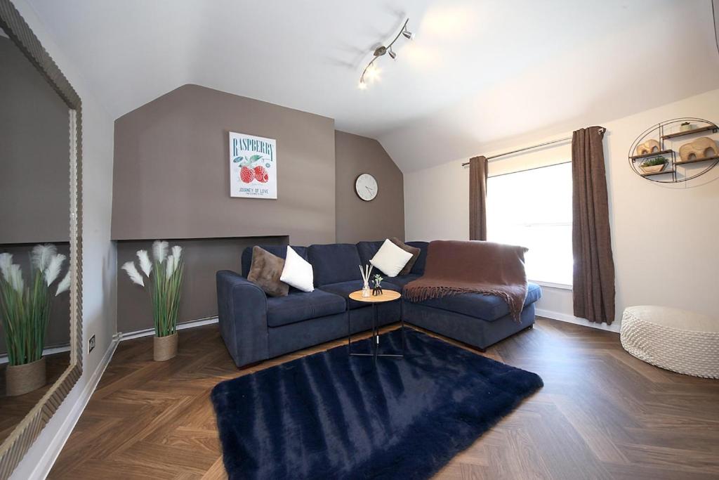 a living room with a blue couch and a chair at Bedford Retreat in Bedford