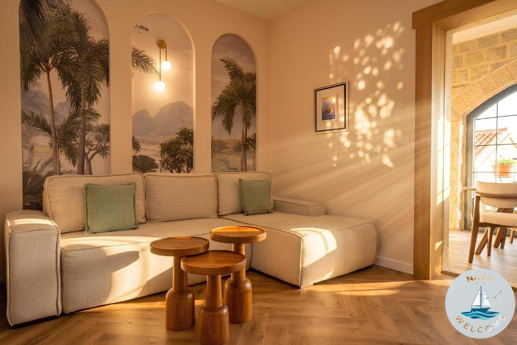 a living room with a couch and two tables at NAVU Apartment in Katun