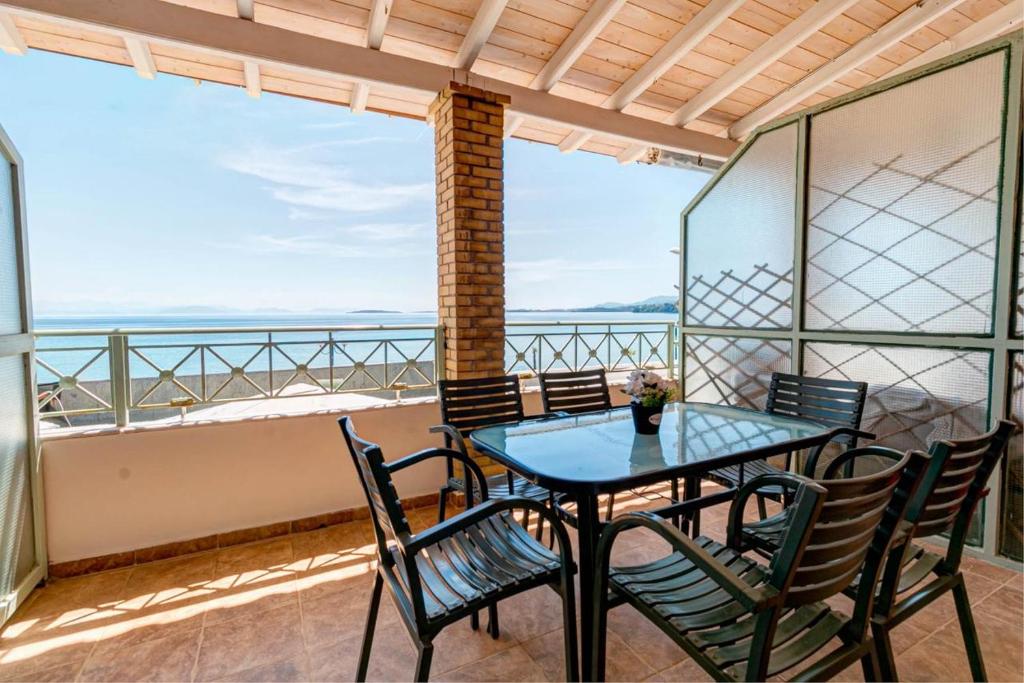 a table and chairs on a balcony with a view of the ocean at Ionelia Hospitality Apartments in Ipsos