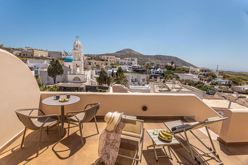 a balcony with a table and chairs and a city at Casita Suites in Megalochori