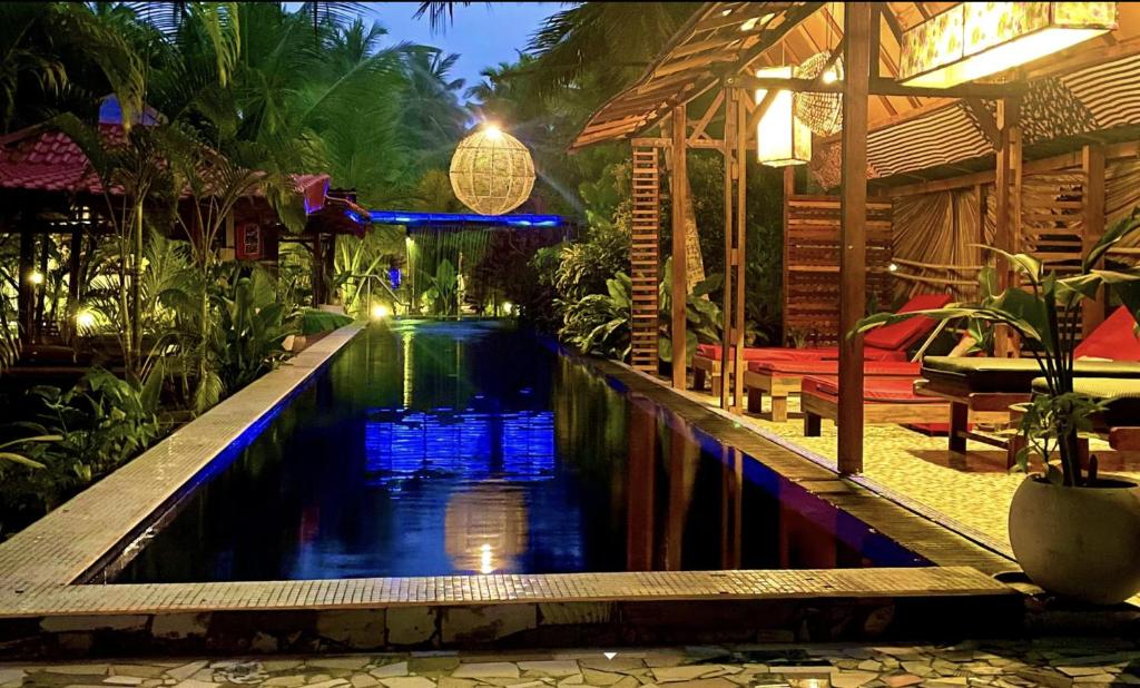 a swimming pool in a resort at night at Red Coconut Villa in Bentota