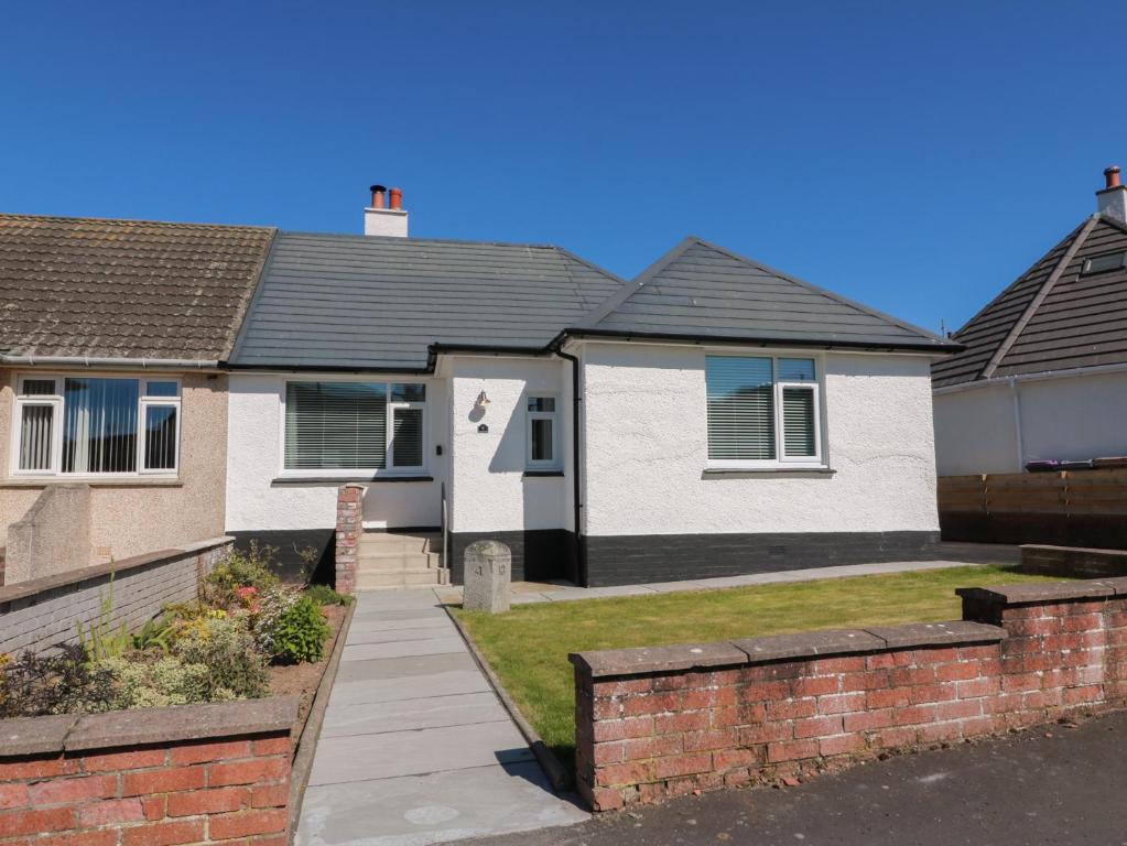 a house with a pathway in front of it at Castaway Cottage Maidens in Girvan