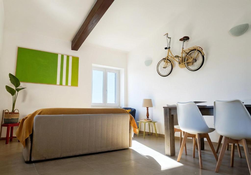 a living room with a couch and a bike on the wall at Le Fonti in Manziana