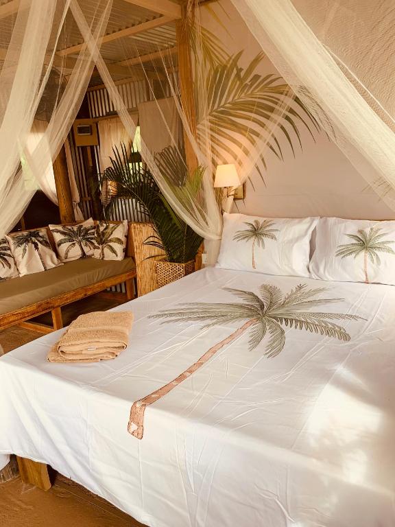 a bedroom with a white bed with a palm tree on it at Lotus Lodge Ocean View in Port Mathurin