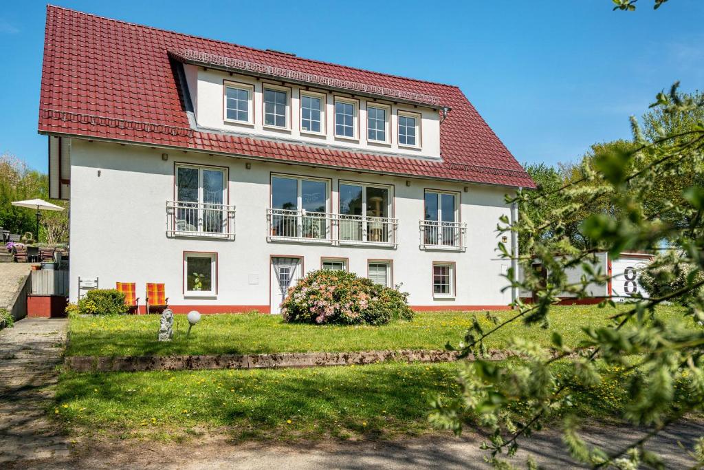 a white house with a red roof at Ferienapartment Sunshine in Zwinge
