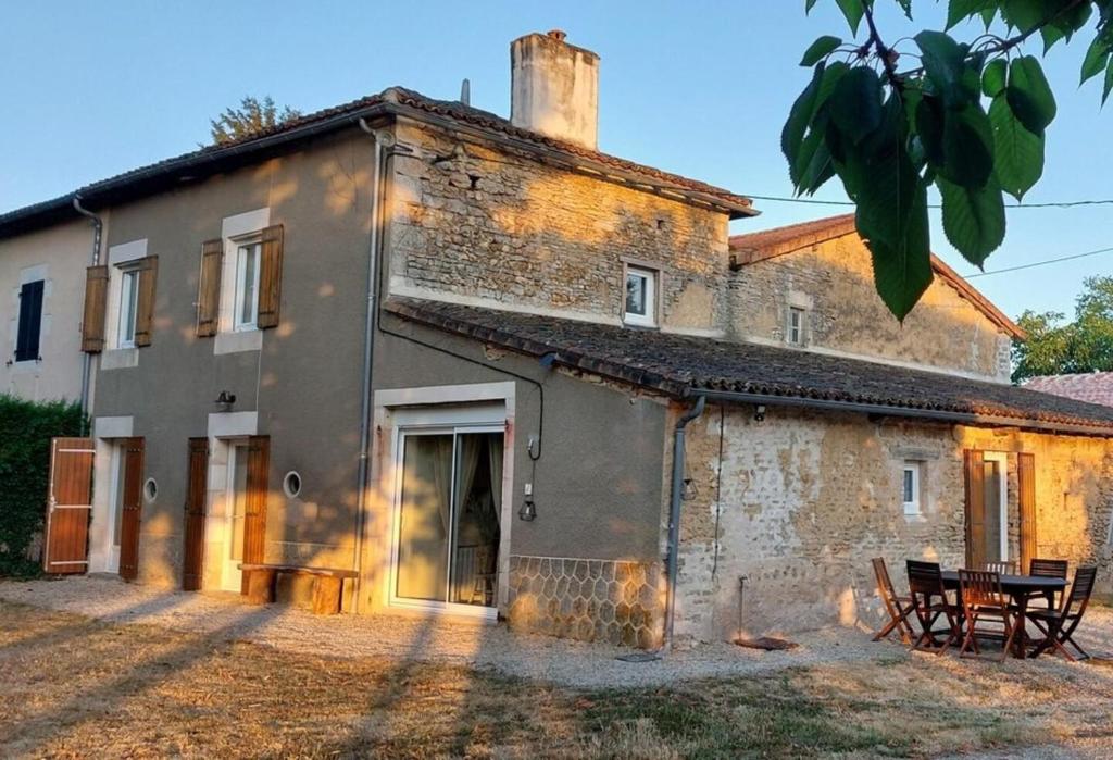 an old stone house with a table in front of it at Gite le rémijour in Céaux-en-Couhé