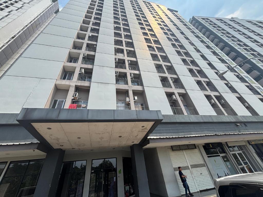 a tall building with a person standing in front of it at Collection O Expressia Stay in Tangerang