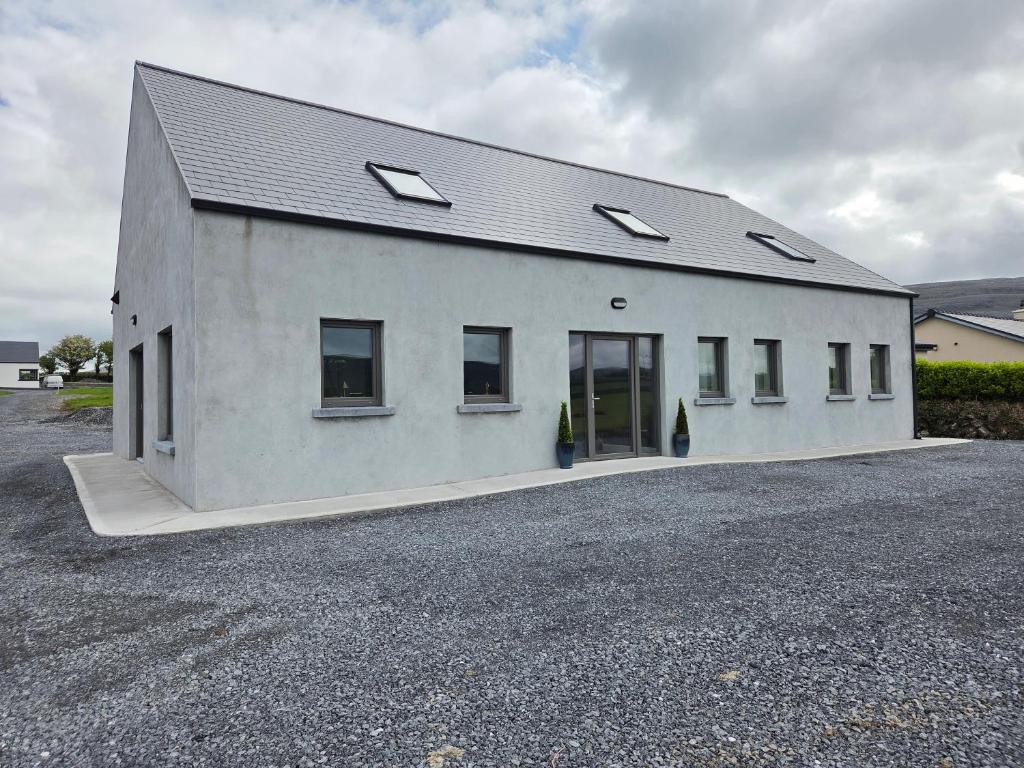 a white building with windows on the side of it at Sheehan's in Bealaclugga