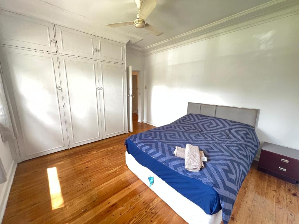 a bedroom with a bed with blue sheets and white cabinets at Room51 in Sydney