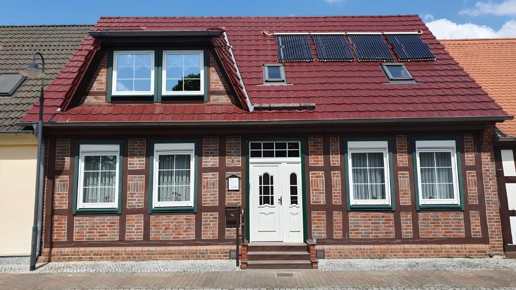 a house with a red roof and white doors at Ferienwohnung 2 in Bad Wilsnack