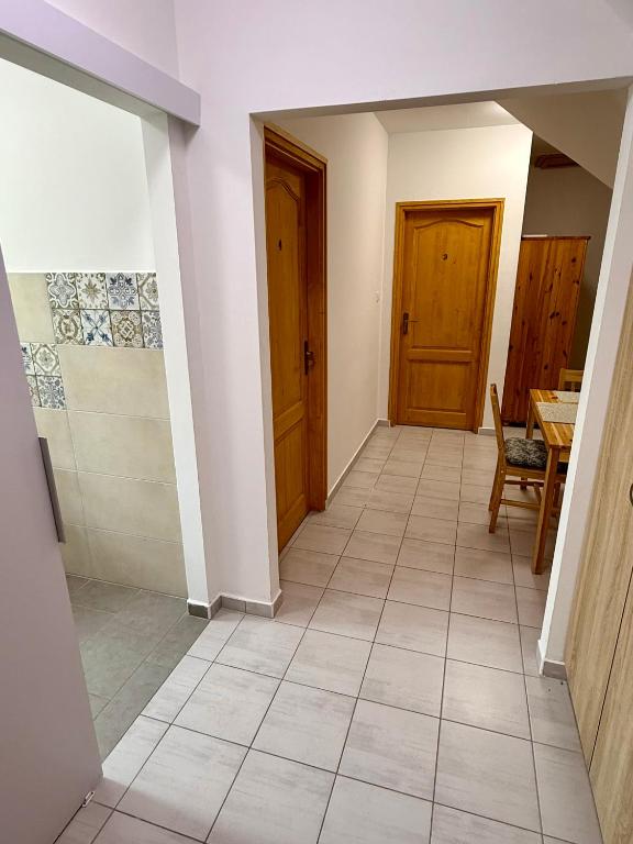 a hallway with two doors and a tiled floor at Kékkúti Apartman in Kékkút