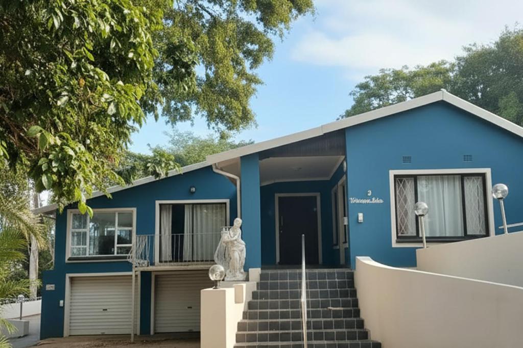 a blue house with stairs in front of it at Nolangeni Lodge in Margate