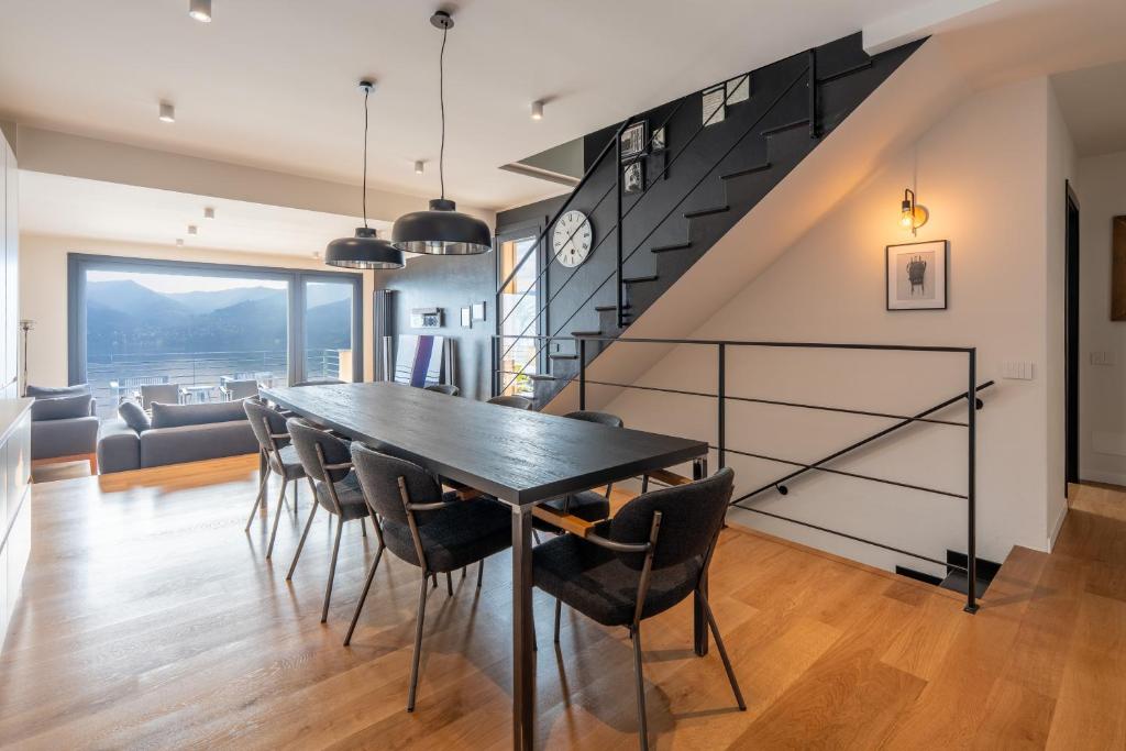 a dining room with a black table and chairs at Lake Como View 3BR Regina 35 in Carate Urio