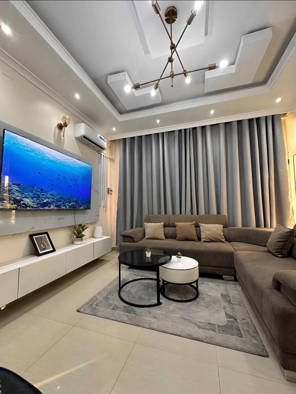 a living room with a couch and a tv at Charming apartment limete 1ere rue Kinshasa in Kinshasa