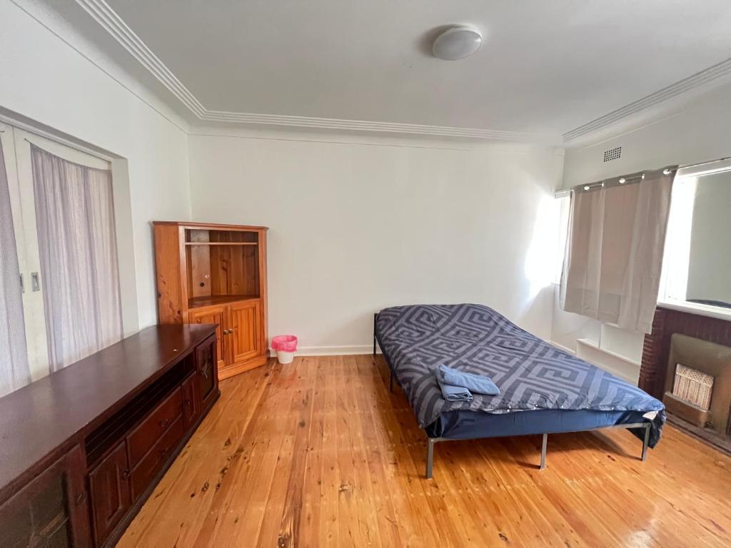 a bedroom with a bed and a wooden floor at Room 53 in Sydney