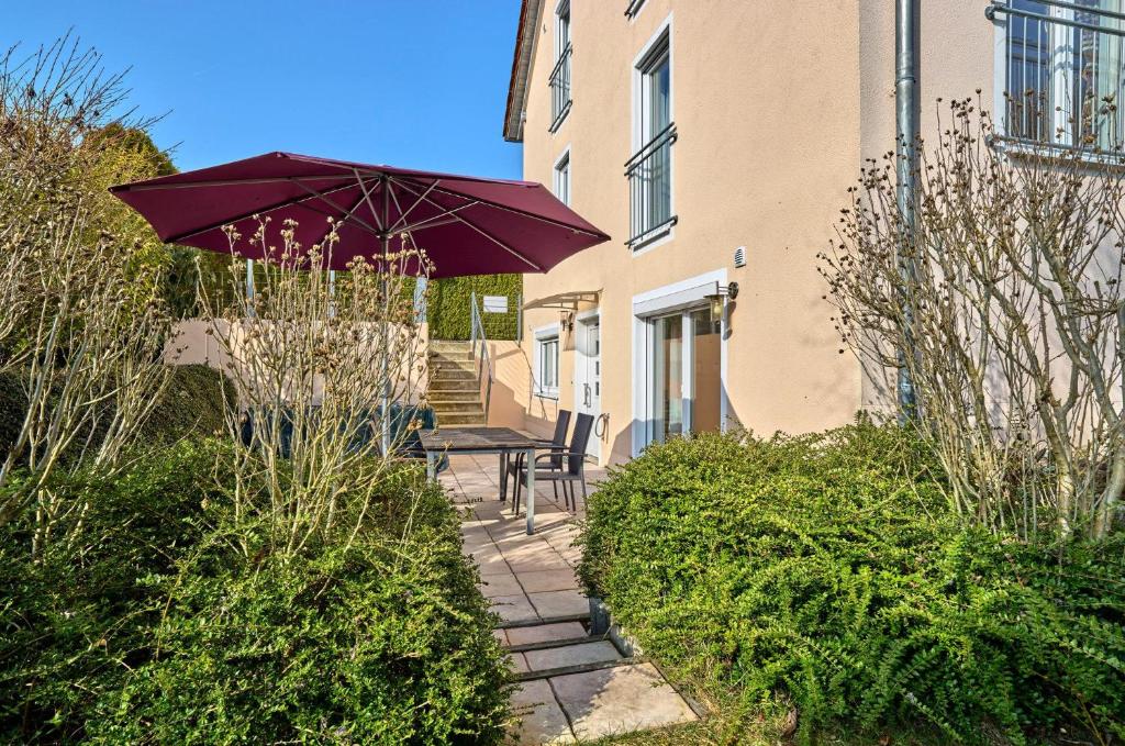 a patio with a table and a purple umbrella at Ferienwohnung im Goldtal in Bad Abbach