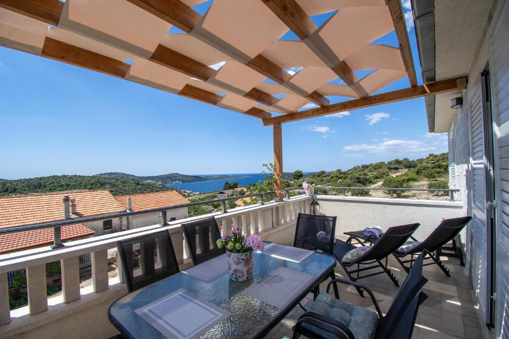 a patio with a table and chairs on a balcony at Apartmani Selo Luka in Ražanj