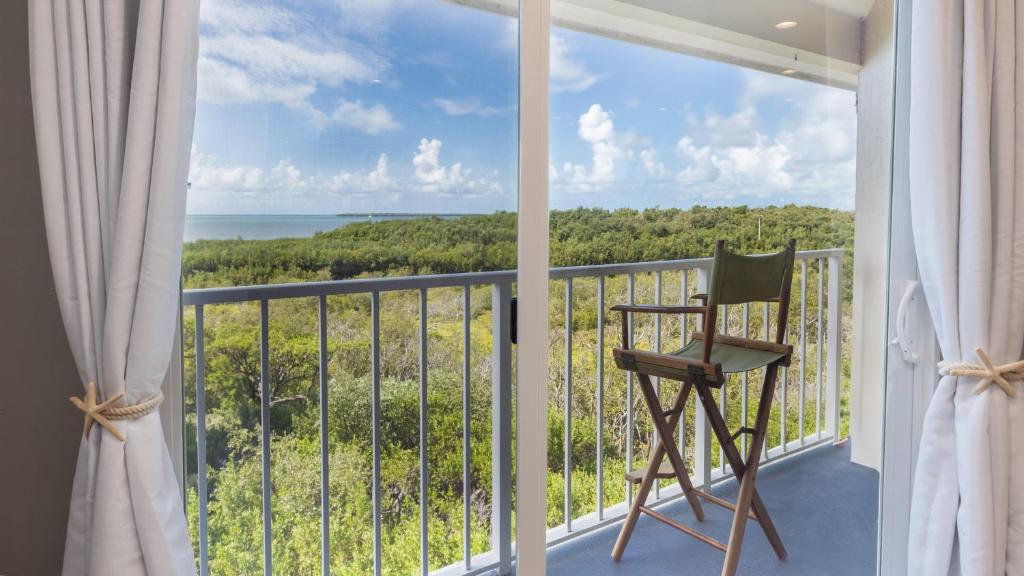 a balcony with a chair and a view of the ocean at 2402 Ocean Pointe in Tavernier