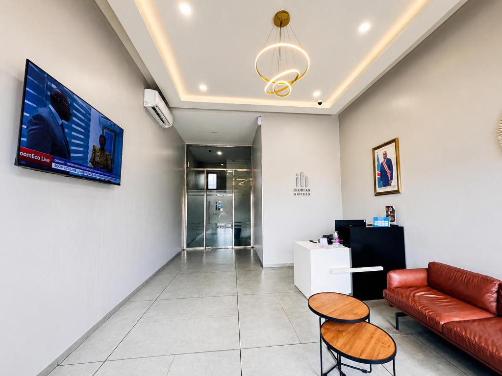 a living room with a couch and two chairs at Ixoras Hotel Lemba in Kinshasa