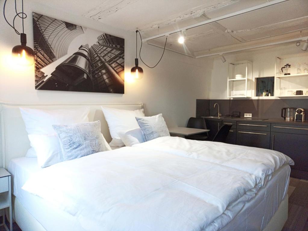 a bedroom with a large white bed and a kitchen at NOX HOTEL - Digital-Check-In - No Reception - nahe Bretten & Karlsruhe - 5 Future in Wössingen