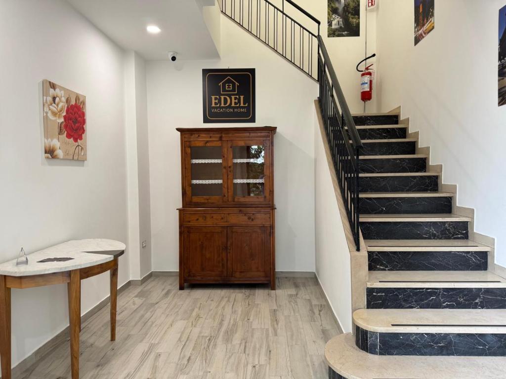 a hallway with a staircase and a wooden stair case at EDEL Vacation Home in Terni