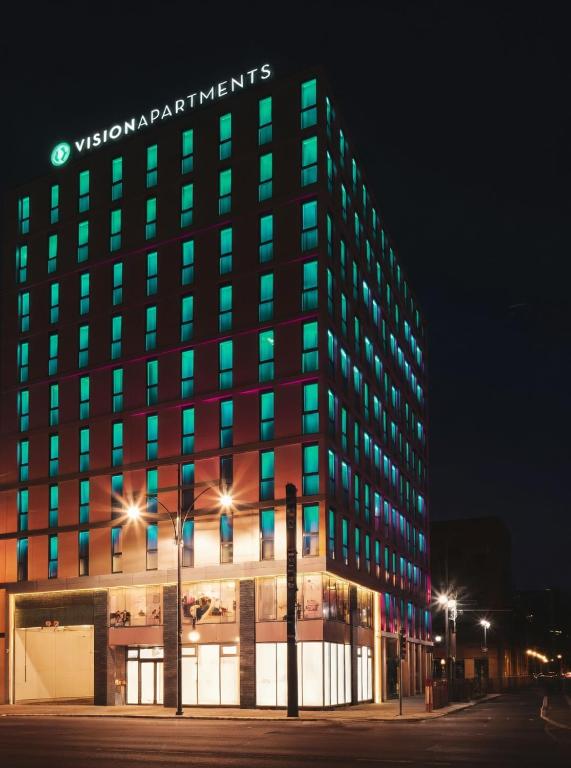 a building with a sign on top of it at night at VISIONAPARTMENTS Berlin - self check-in in Berlin