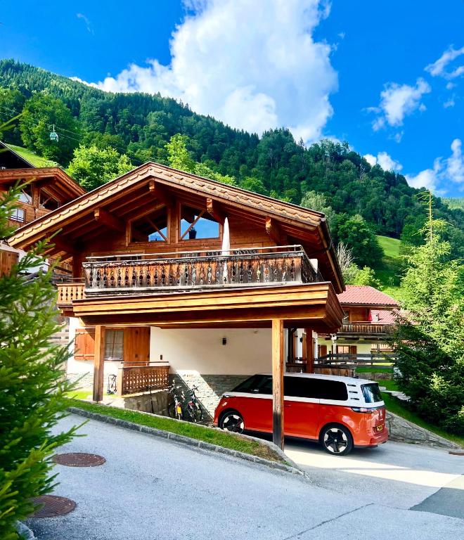 a van parked in front of a building with a balcony at Chalet Cosy in Bramberg am Wildkogel