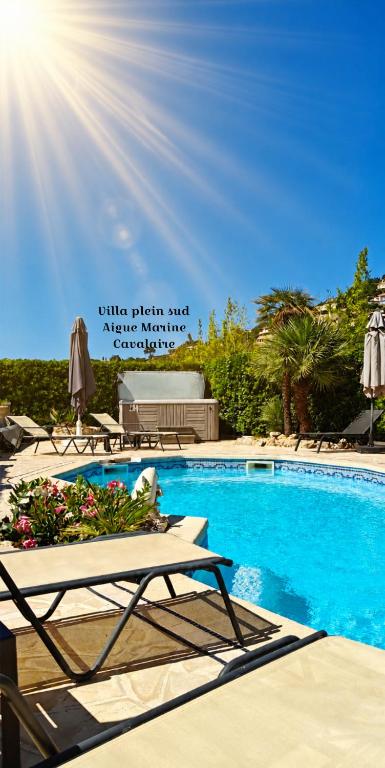 a swimming pool with two lounge chairs and the sun at VILLA Plein Sud Piscine Spa Climatisation Parking privé calme et détente in Cavalaire-sur-Mer
