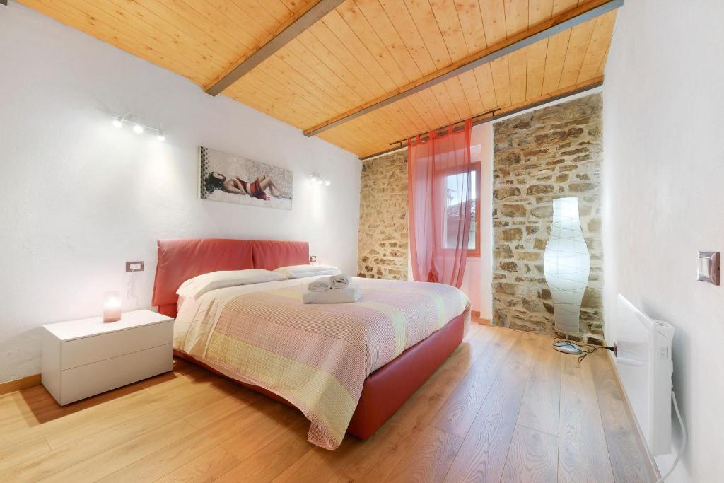 a bedroom with a bed and a brick wall at Prima Del Cielo - Alba Apartment in Perledo