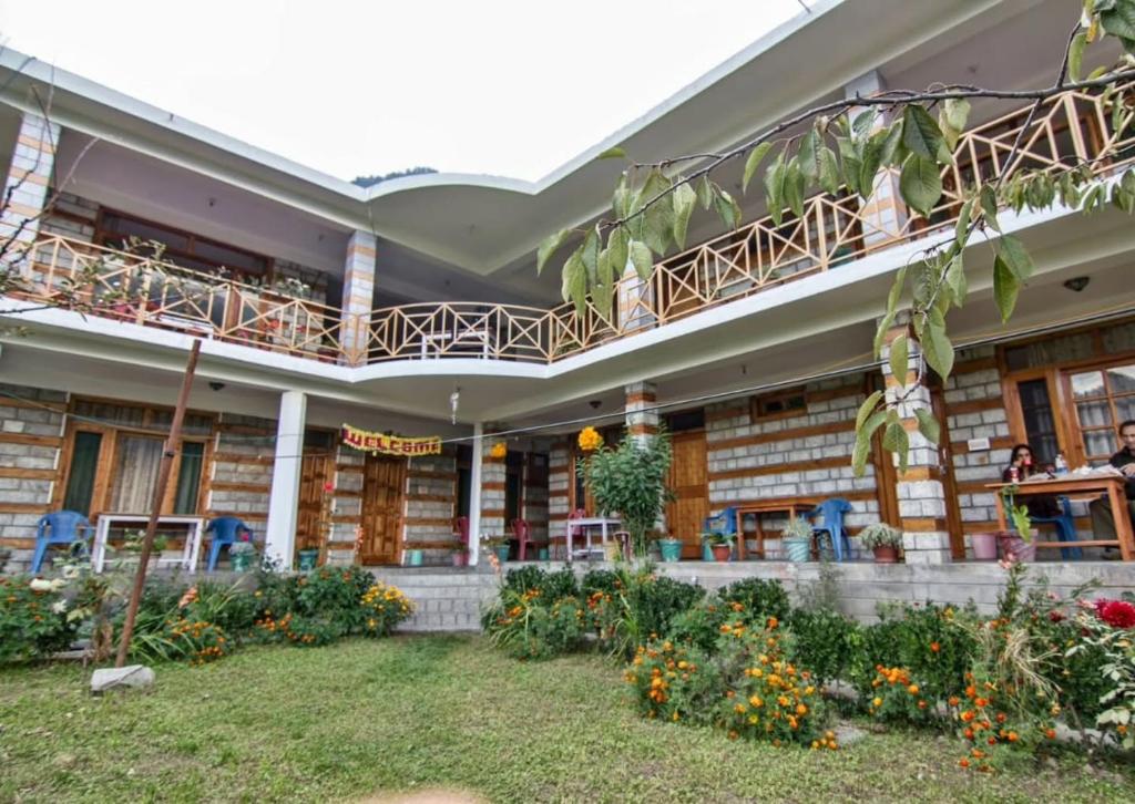 a building with balconies and flowers in the courtyard at Monal House in Manāli