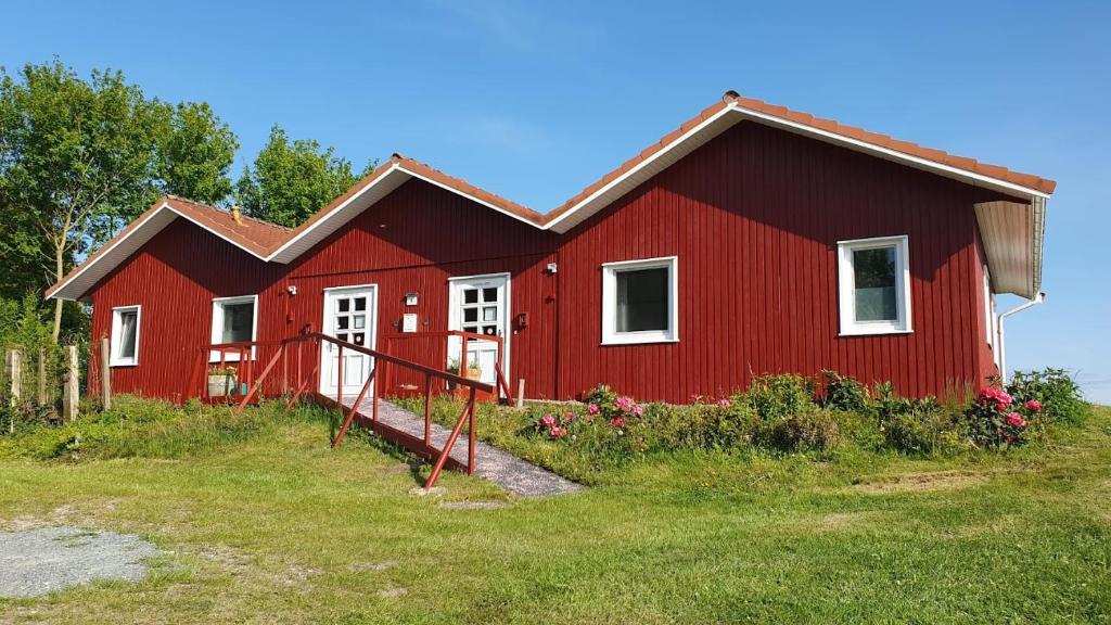 a red house on a hill with flowers in front of it at Ferienwohnung Saustrup in Saustrup