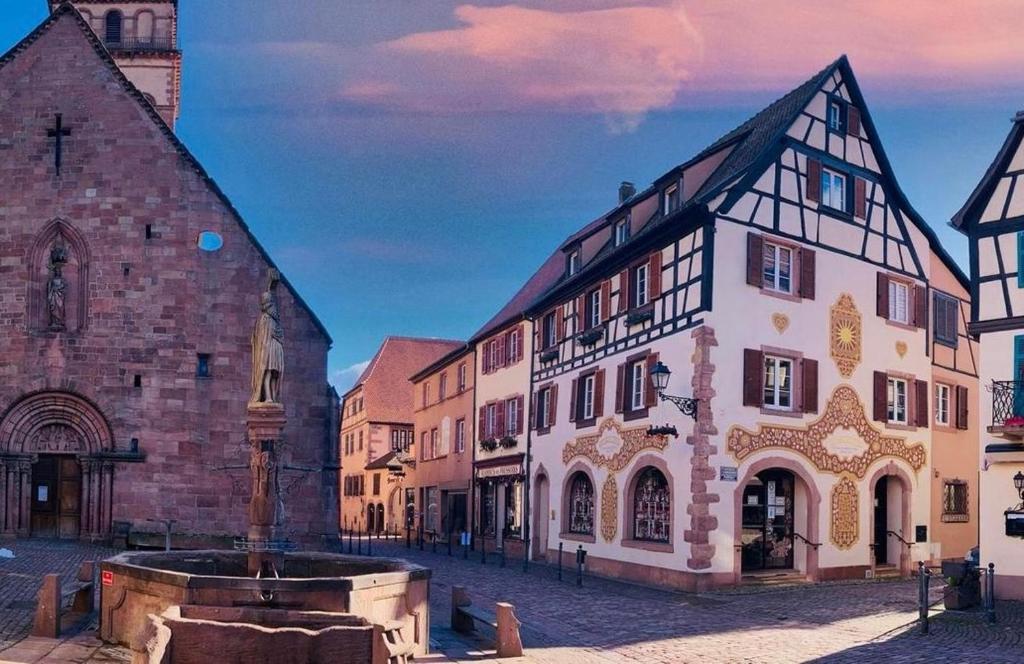 a group of buildings on a street with a church at La Terrasse du Tonnelier - 92m2 - plein centre médiéval - sauna - terrasse 20m2 - garage in Kaysersberg