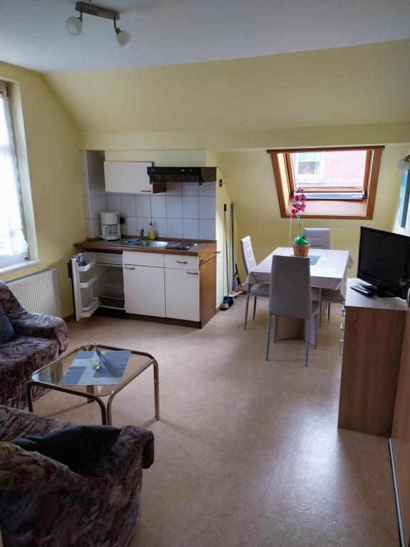 a living room with a table and a kitchen at Ferienwohnung Stechlin, Neuglobsow in Stechlin