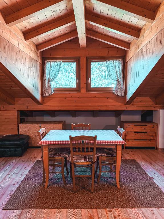 a dining room with a table and chairs in a cabin at Mansarda Il Castello in Ossana