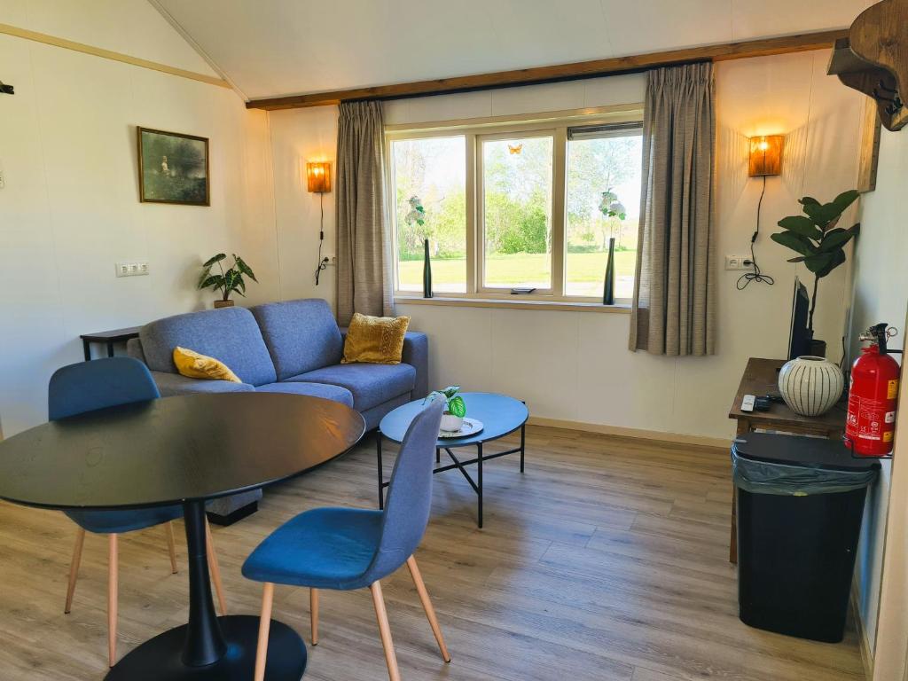 a living room with a blue couch and a table at 2-persoons luxe vakantiewoning in De Veenhoop