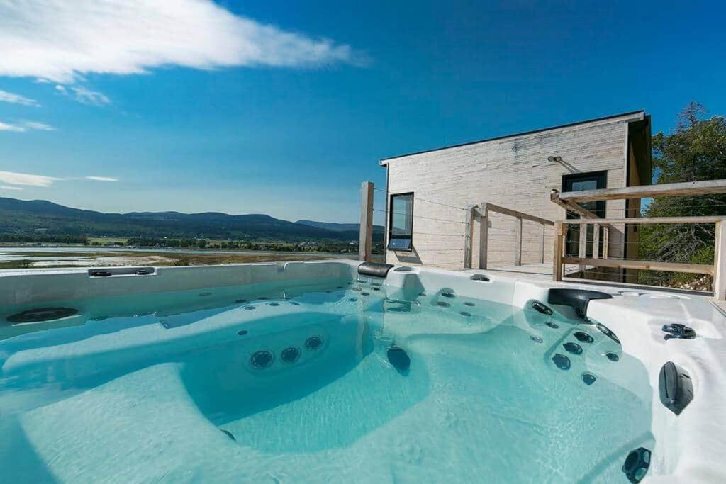 a large swimming pool in front of a building at Hôtel à la maison - Panache, spa et fleuve in Baie-Saint-Paul