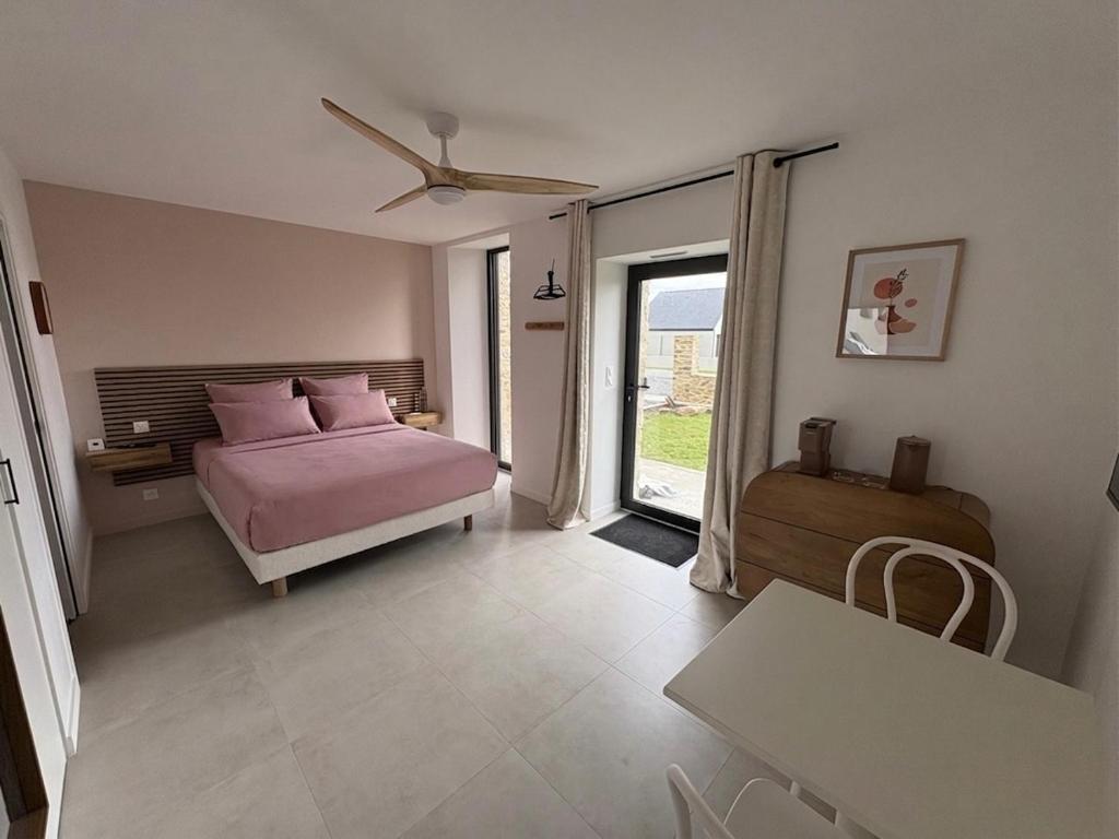 a bedroom with a bed with pink pillows and a window at Chambre d'hôtes Lilas in Saint-Lyphard